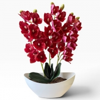 Artificial orchid Cymbidium in a vase - a realistic decorative composition for the interior